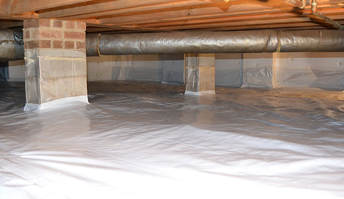 Clean encapsulated crawl space with white vapor barrier on ground and piers