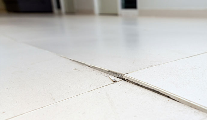 Cracked and shifted floor tiles caused by slab movement