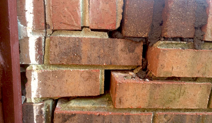 Cracked and shifting brick foundation wall