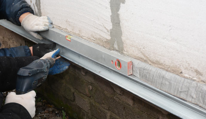 Professional service team repairing residential foundation