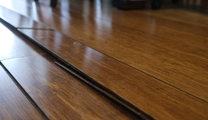 Uneven wooden floor with buckled and lifted boards