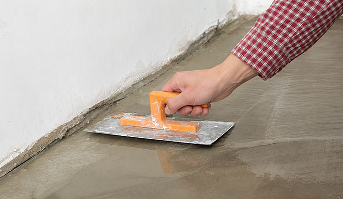 Finishing trowel smoothing concrete foundation floor