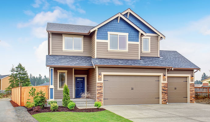 Exterior view of a modern residential house with landscaped garden and lawn area