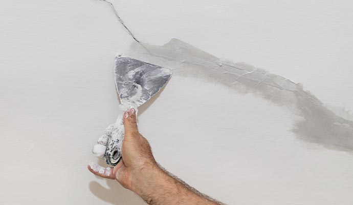 Professional repairing wall crack with equipment